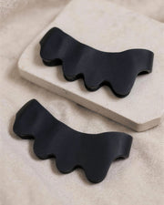 KinetiPath Reflex toe spacers seen from a low angle on a pale stone slab, showing the soft rubber thickness