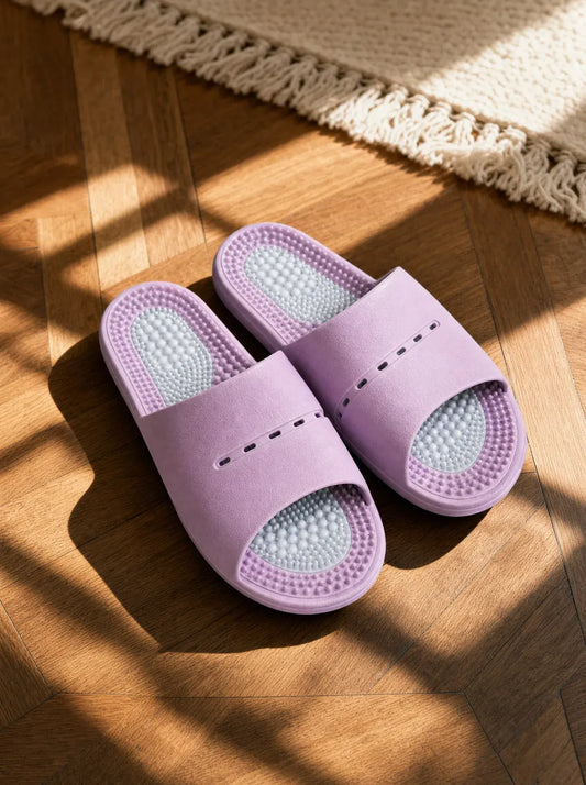 Nocturne — Meridian women's reflexology slides in lilac, resting on a warm oak floor beside a linen rug in morning light